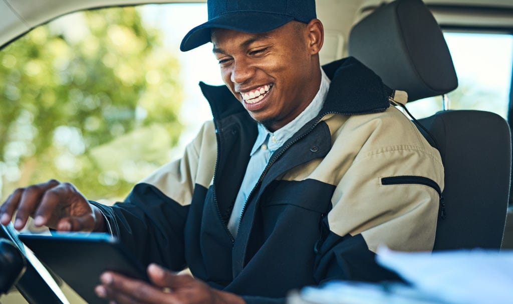 a man smiling while looking at a phone