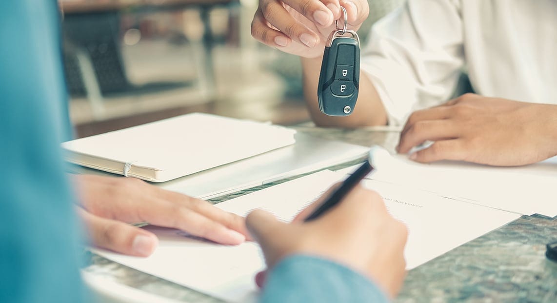 a person handing a car key to another person