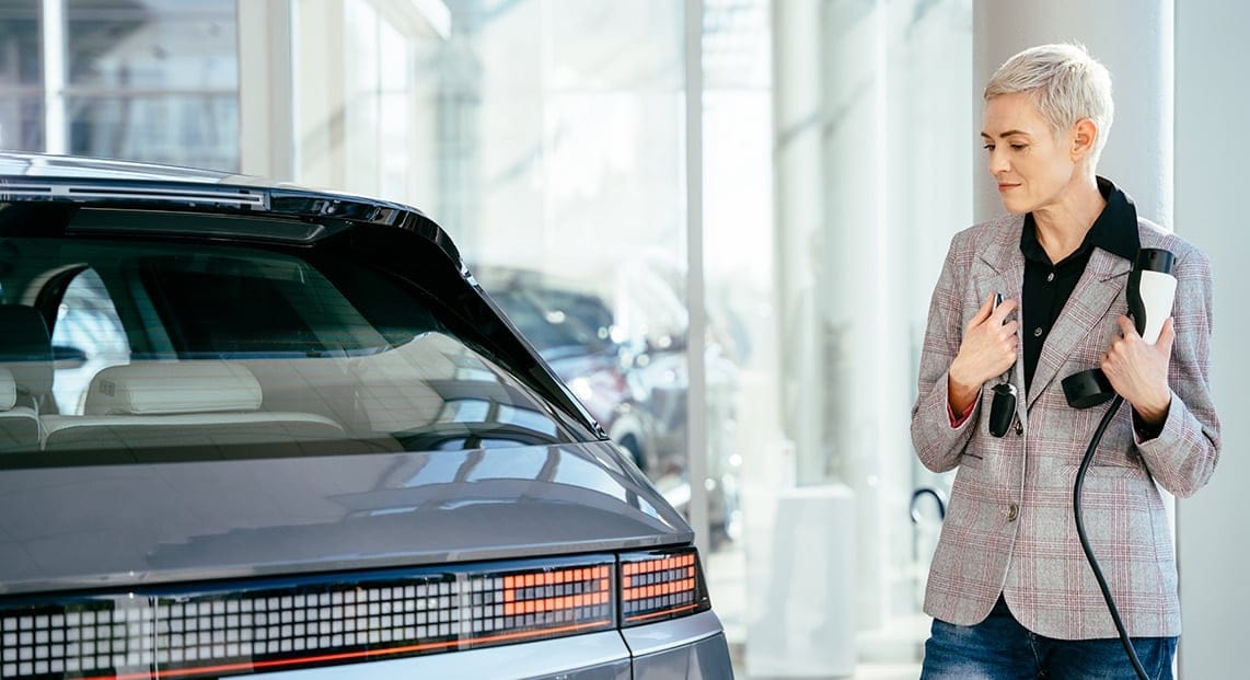 a woman standing next to a car
