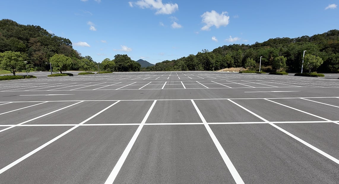 a parking lot with trees in the background
