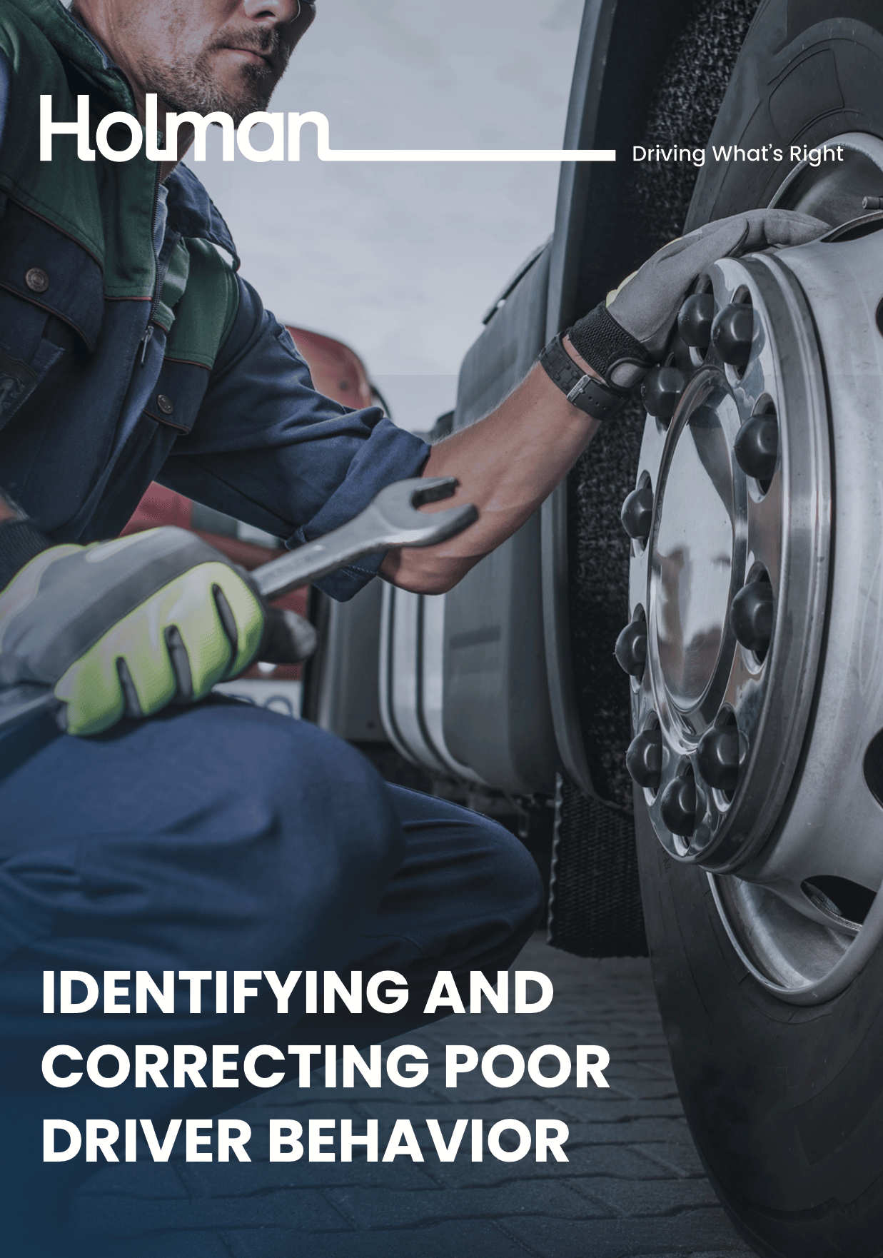 Man looking at a wheel holding a wrench