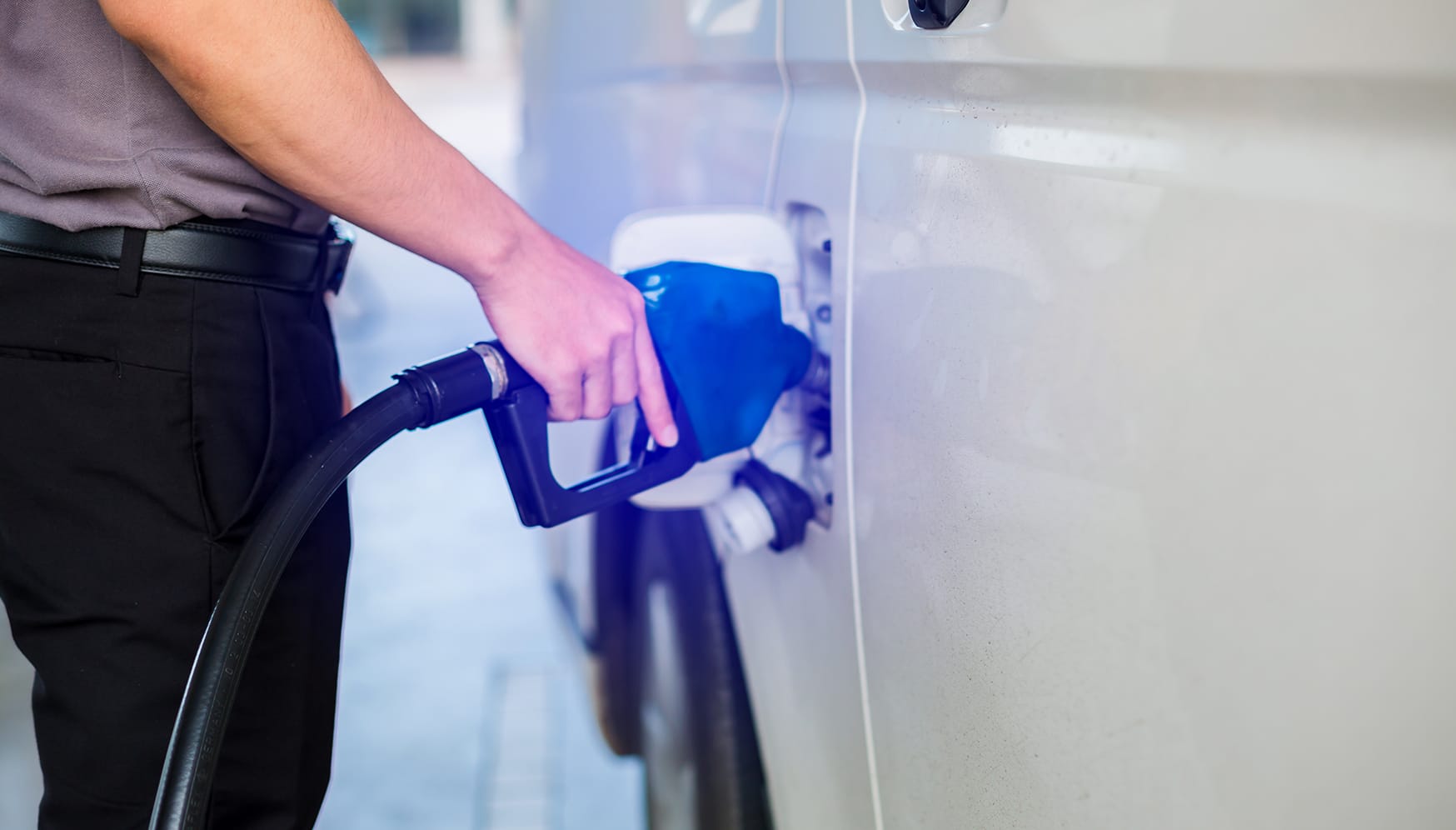 A person pumping fuel into a vehicle