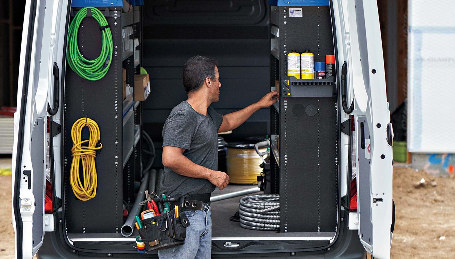 An electrician getting tools from his van