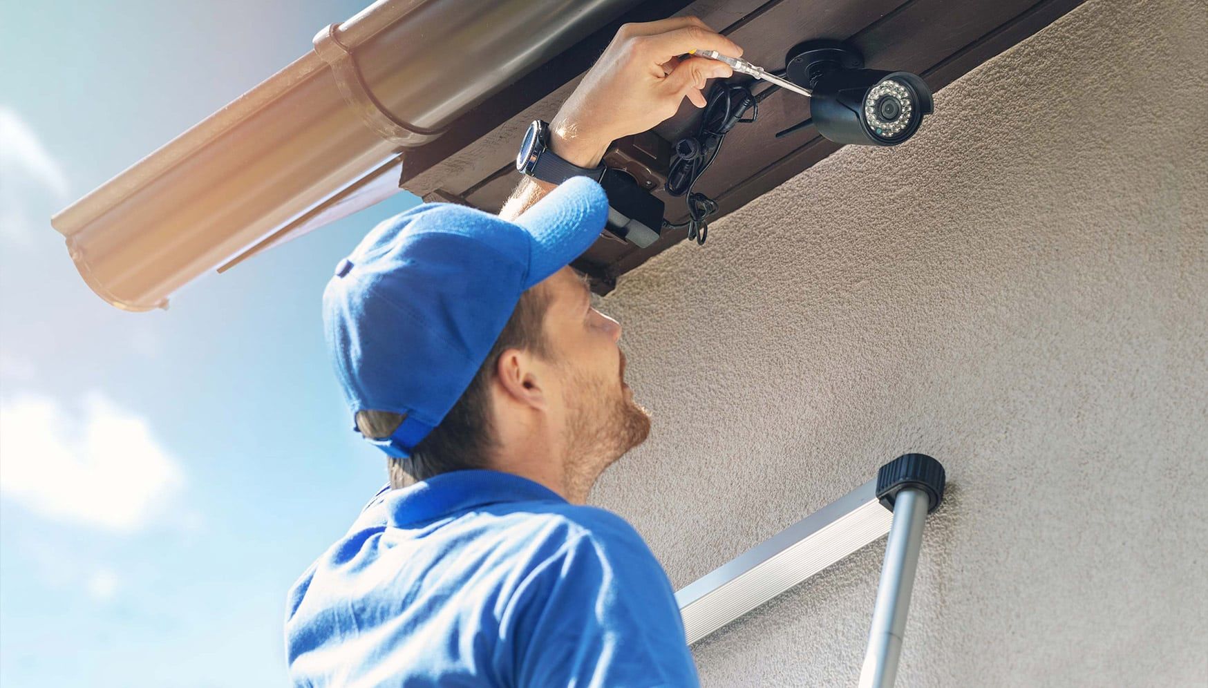 A person installing a security camera