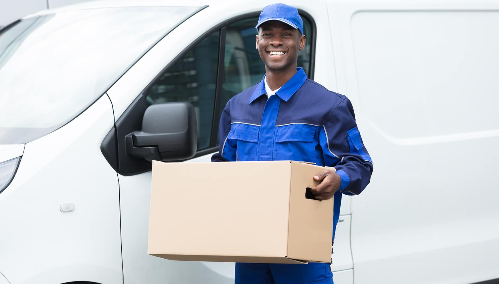 a man in blue uniform holding a box