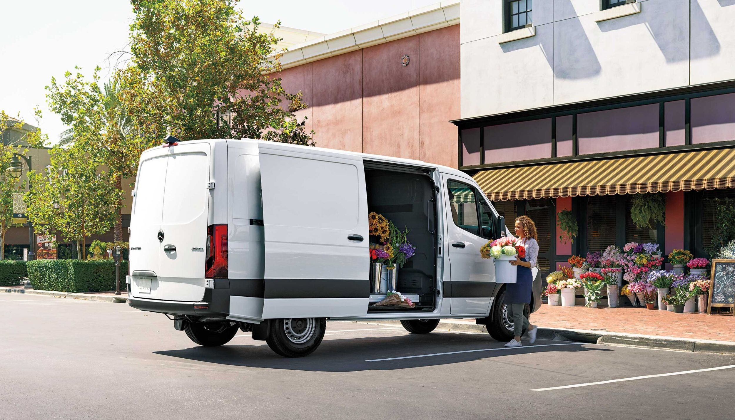 A woman putting flowers into a van