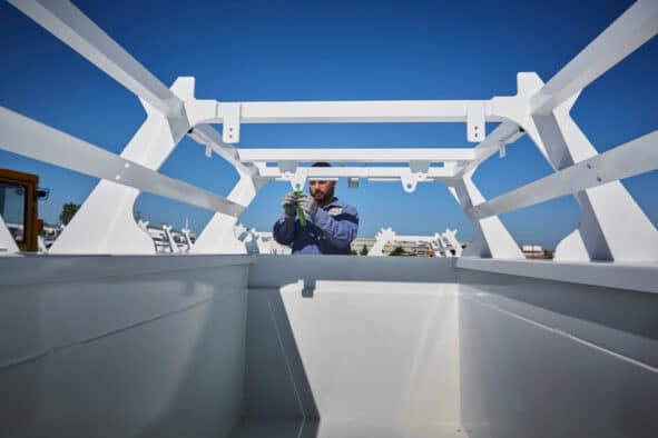 Man adjusting a tape on top of the truck zoomed out