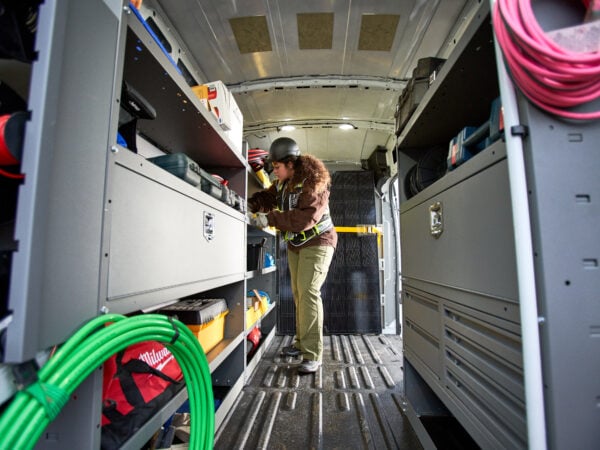a woman in a helmet looking at a tool box