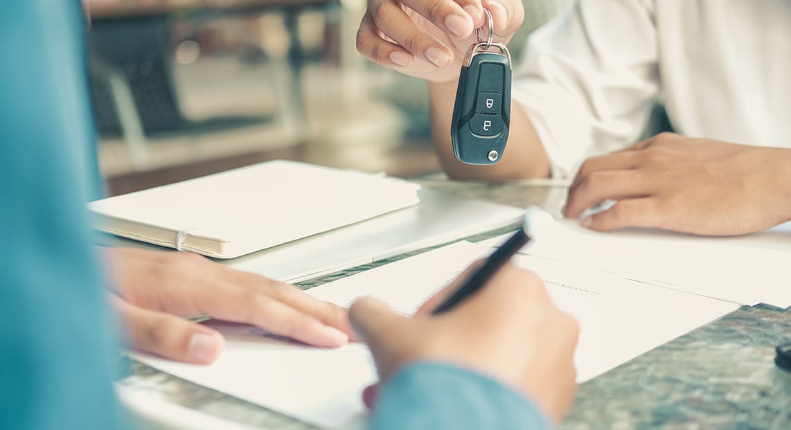 a person handing a car key to another person