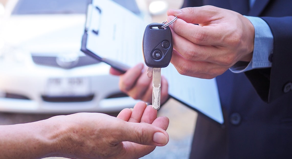 a person handing over a car key