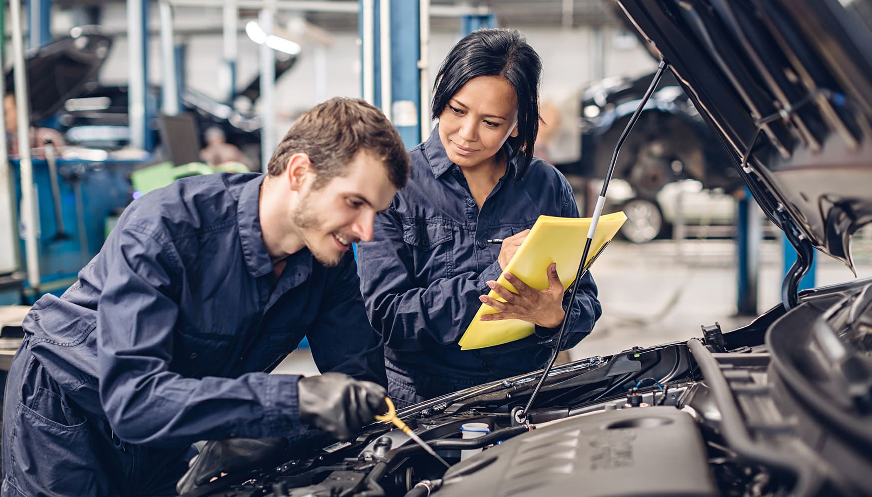 a man and woman in a car repair shop