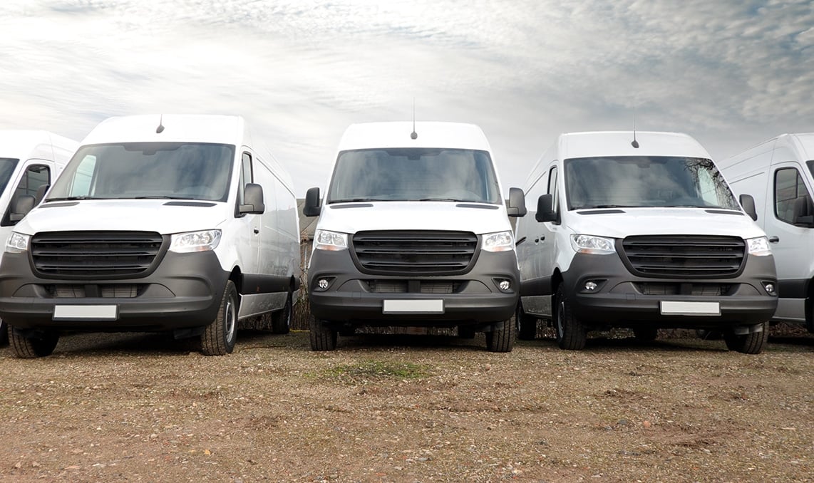 a group of white vans parked in a row