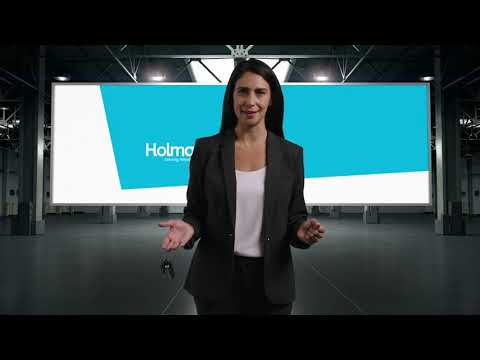 a woman in a suit standing in front of a large screen