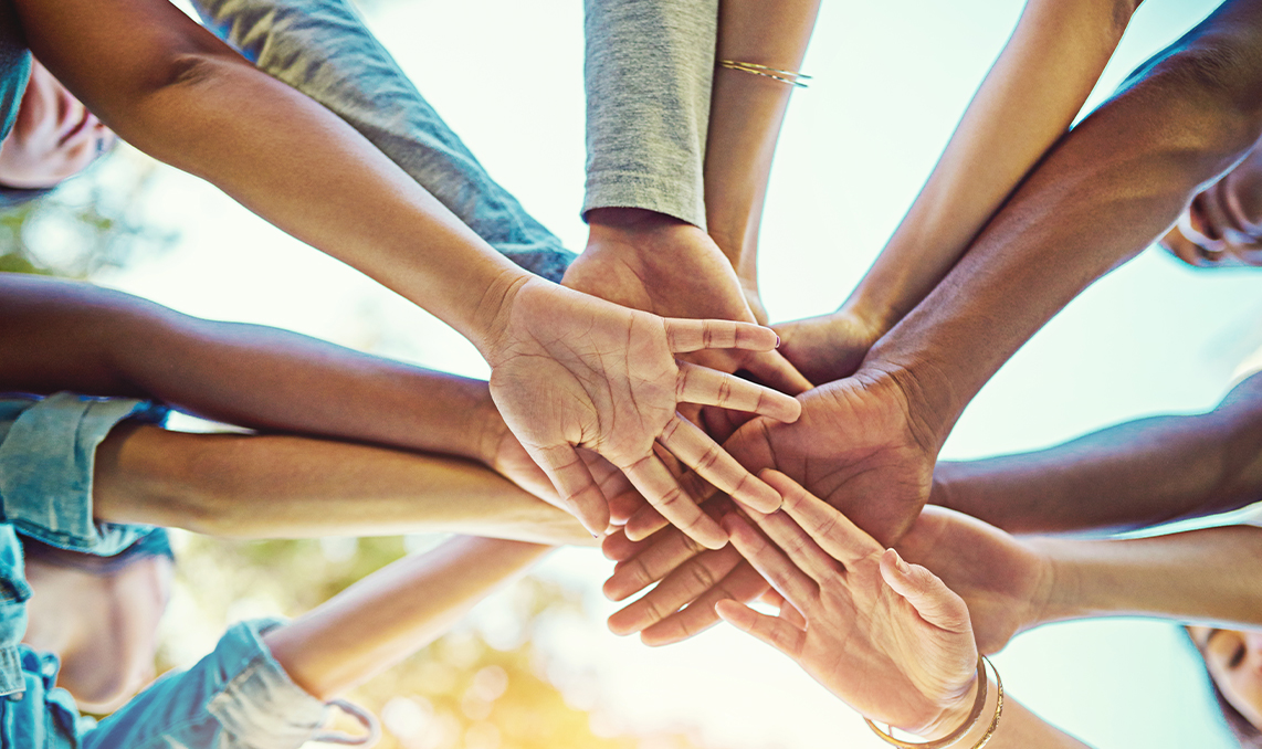 a group of people putting their hands together