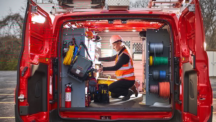 a person kneeling down in an upfitted light-duty van